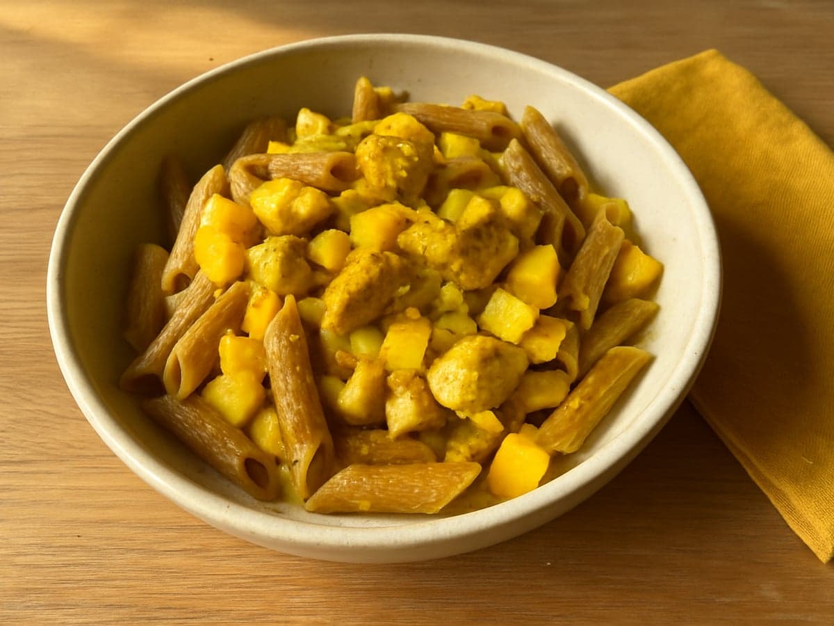 Pasta met kip, kerrie en mango in een schaal