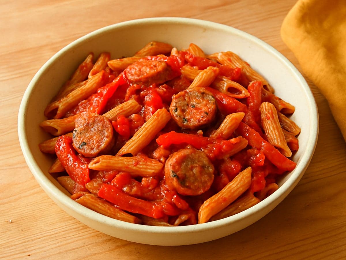 Pasta met worstjes, paprika en tomatensaus in een schaal