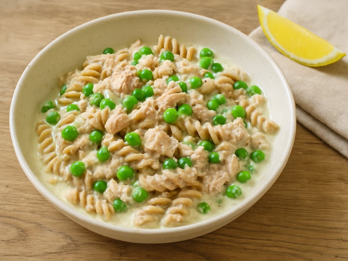Romige pasta met tonijn en doperwten in een schaal